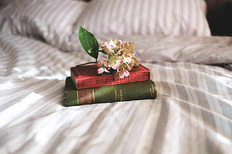 Libros y flor sobre una cama