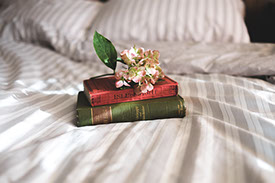 Libros y flor sobre una cama